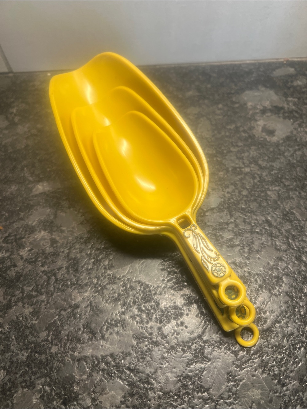 Set of 3 Yellow Vintage Nesting Measuring Cups. No size markings on them.